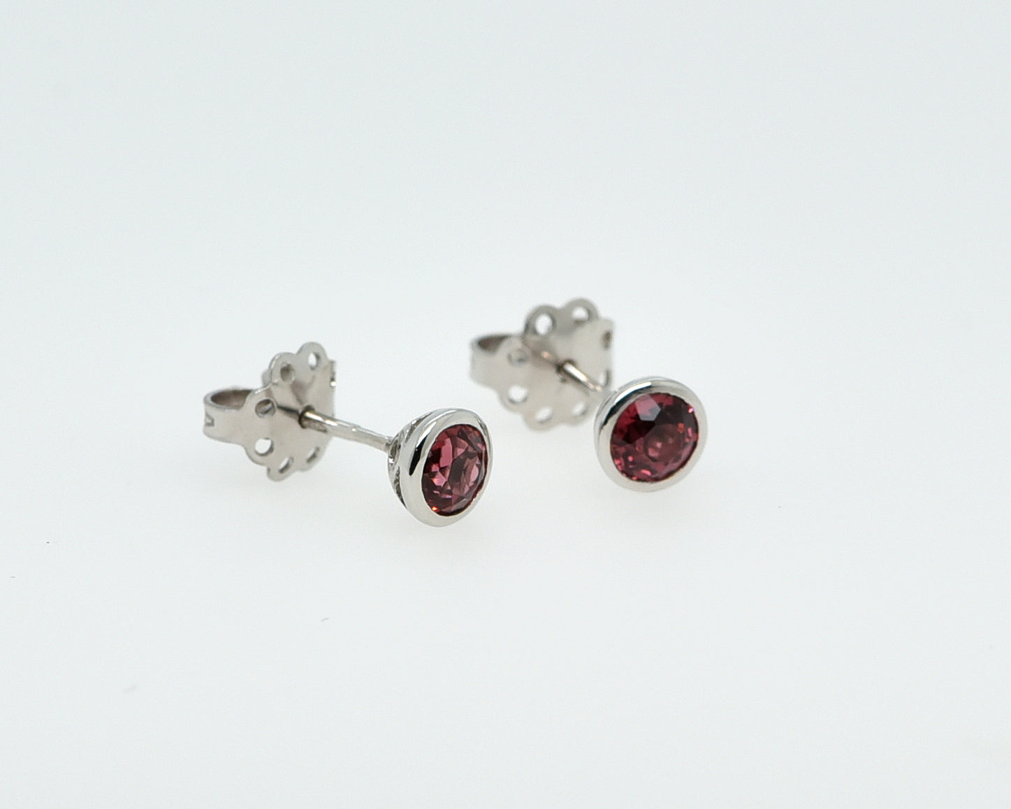 Balto aukso auskarai su turmalinais baltame fone