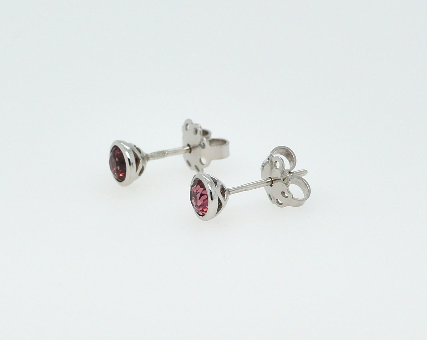 Balto aukso auskarai su turmalinais baltame fone iš šono