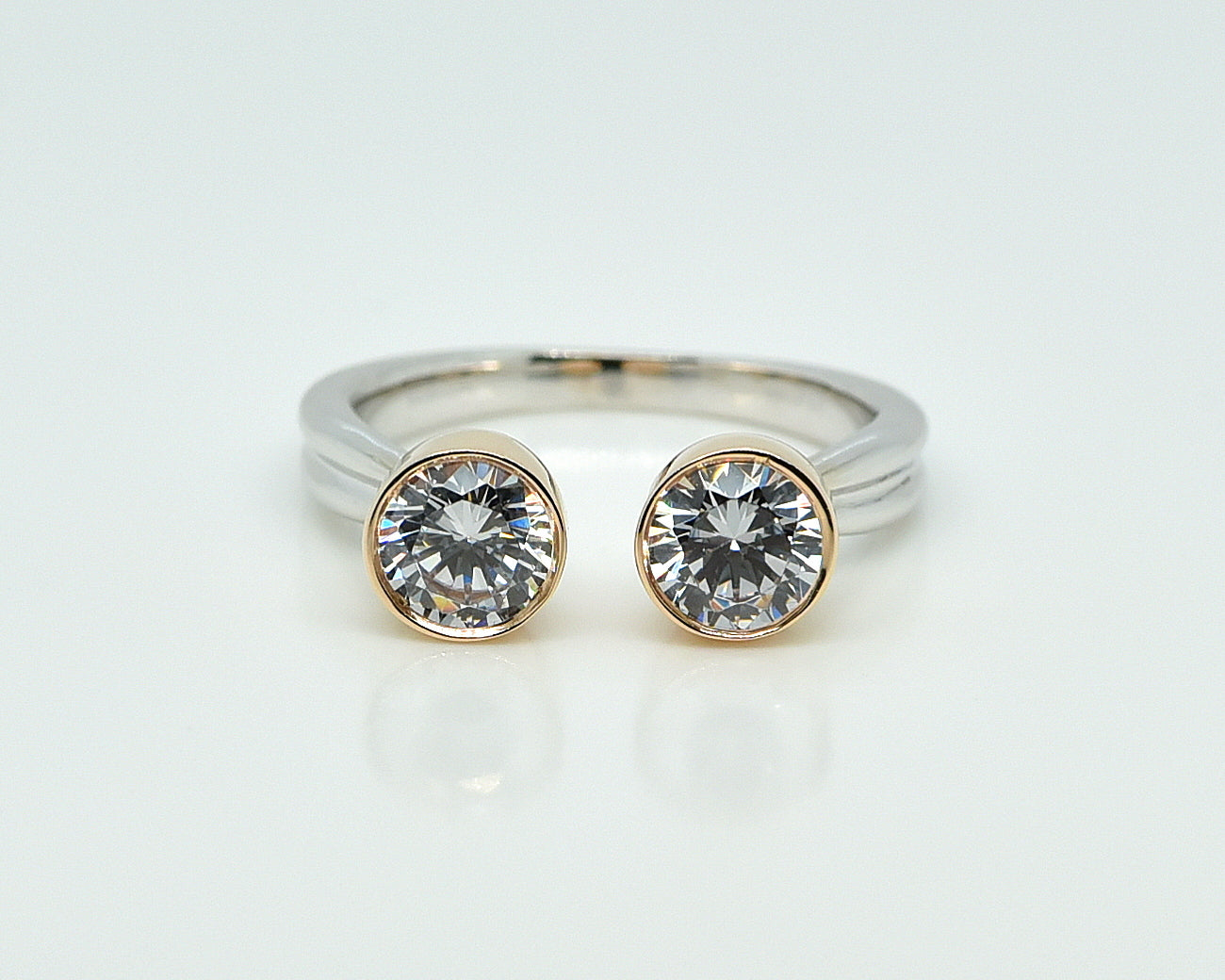 Balto aukso žiedas su geltono aukso karūnėlėmis baltame fone