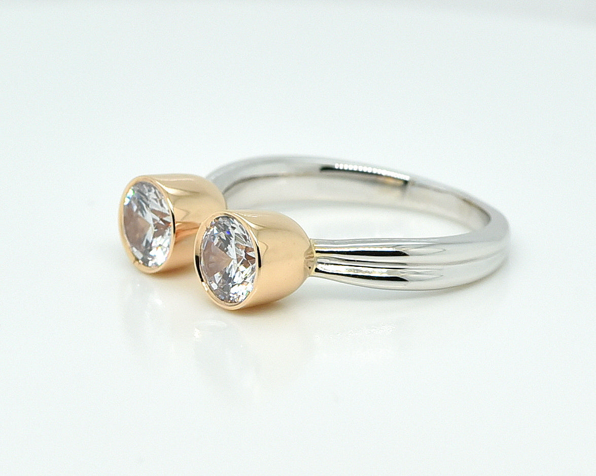 Balto aukso žiedas su geltono aukso karūnėlėmis baltame fone iš šono